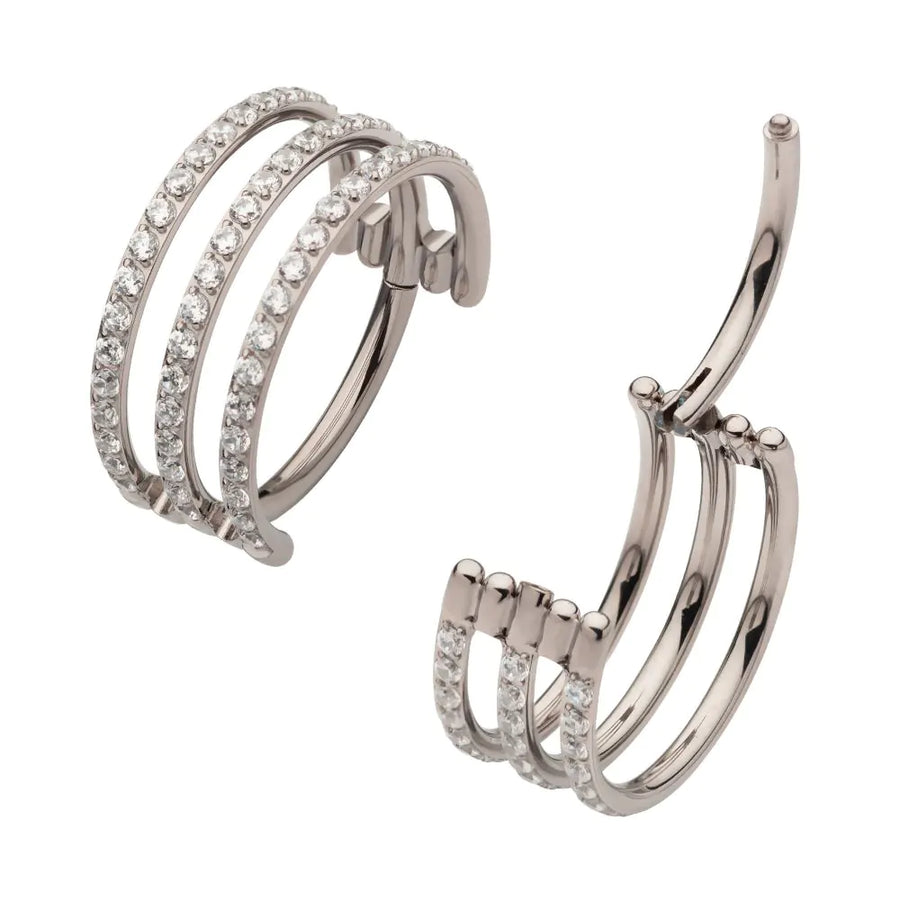 A high-quality silver or titanium triple-stacked septum clicker jewelry piece, featuring three parallel rows of pavé-set clear crystals, shown both closed and in an open hinged position.