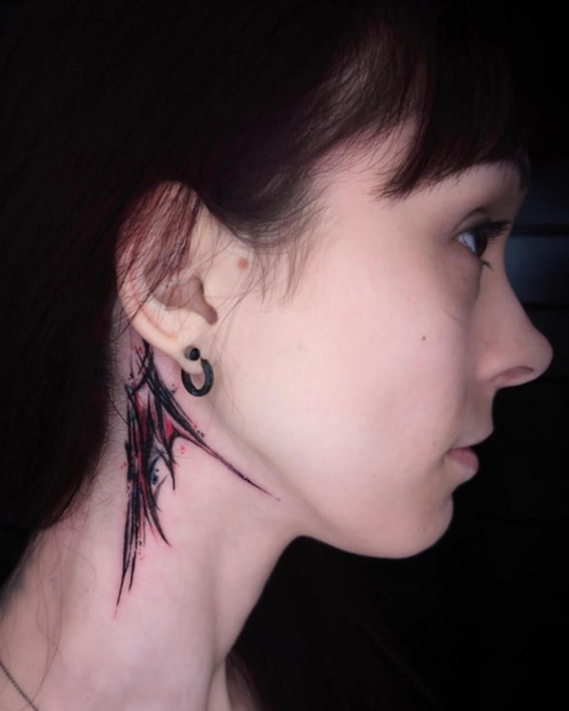 Close-up of a person with a tattoo on their neck against a dark background