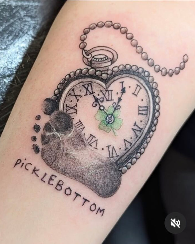 Tattoo of a pocket watch design on a person's arm with 'picklebottom' branding.