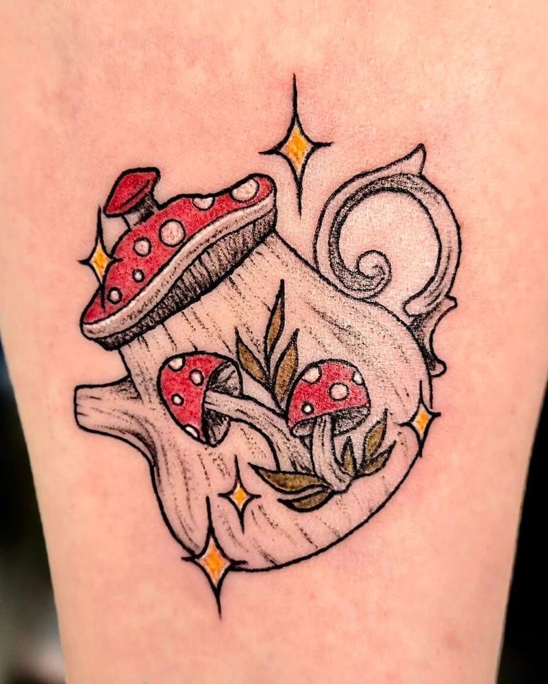 Tattoo of red mushrooms and a teapot on a person's arm.