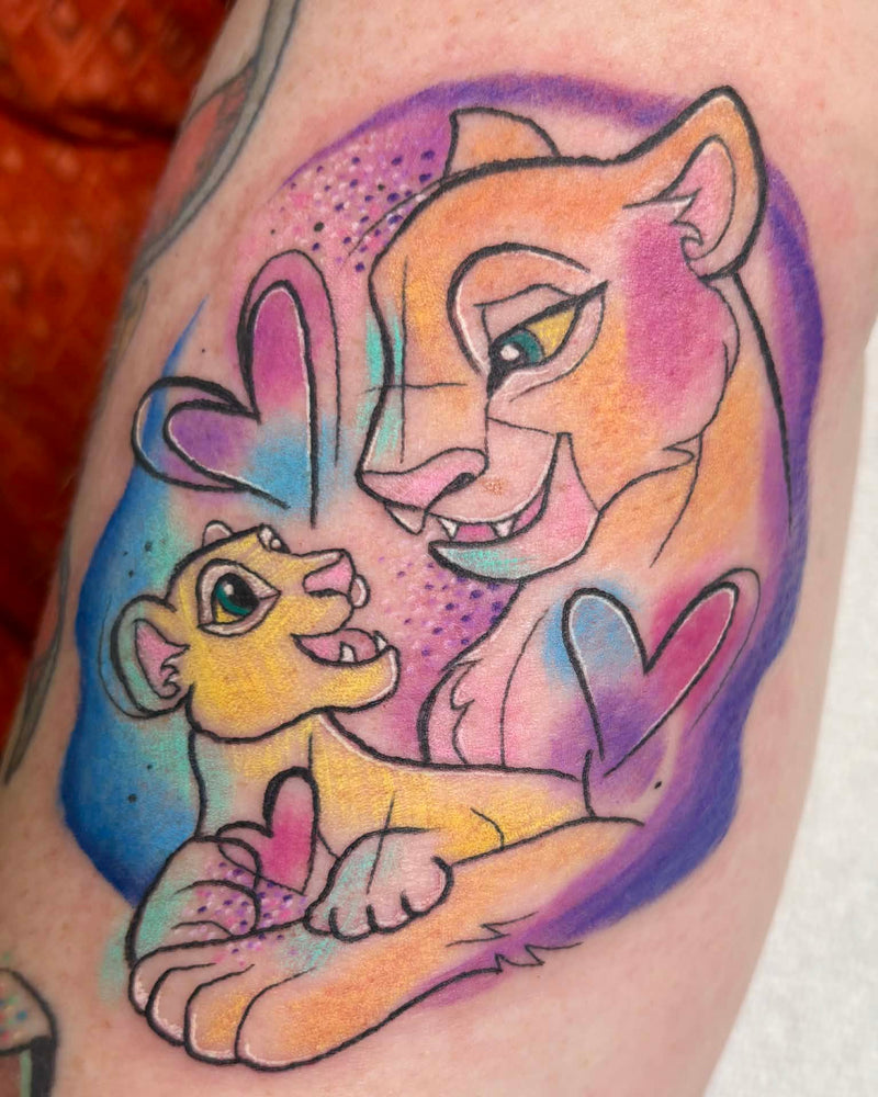 Tattoo of a lioness and cub with colorful hearts on a person's arm.