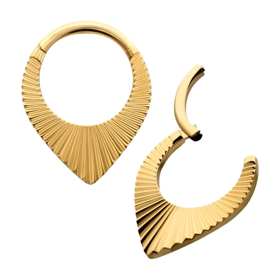 A decorative gold-toned septum clicker or ear jewelry piece featuring a sharp teardrop silhouette with a ridged, sunburst-style texture radiating from the bottom point, shown in both closed and open hinged positions.